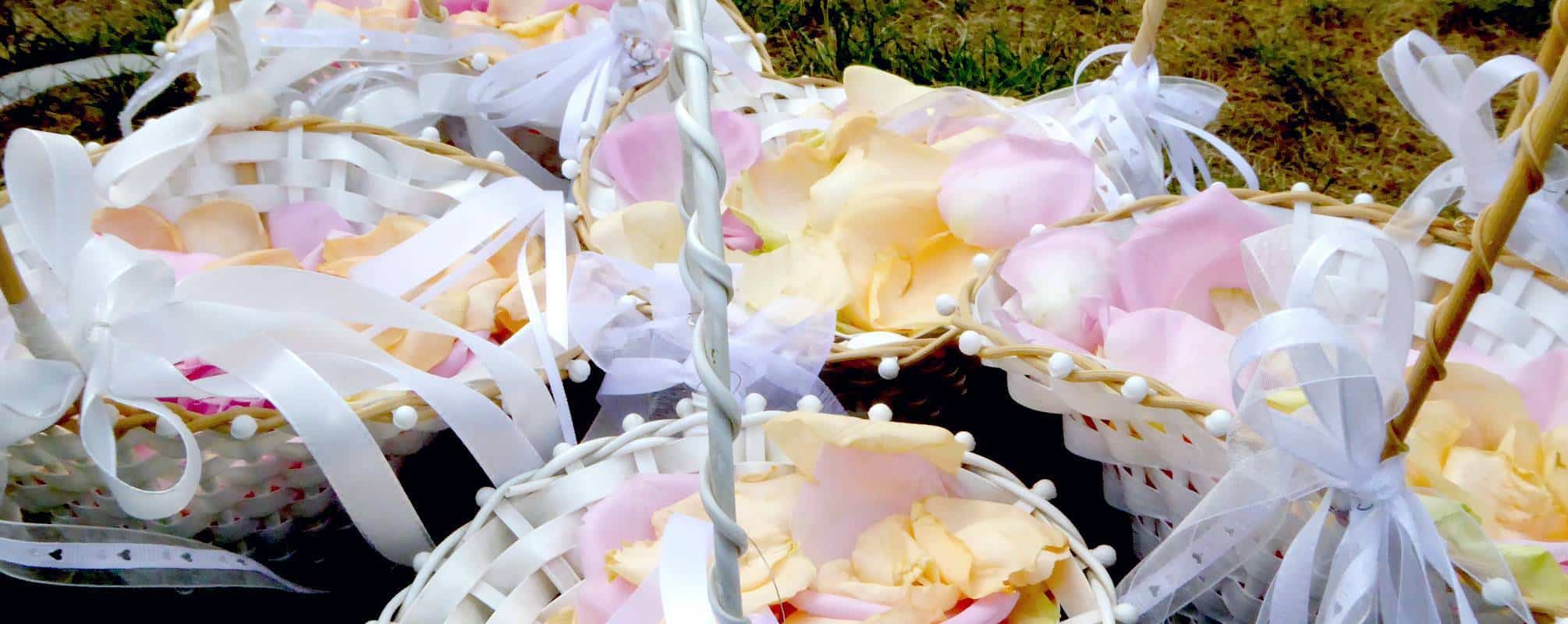 Weiße Körbe mit bunten Rosenblätter zur freien Trauung
