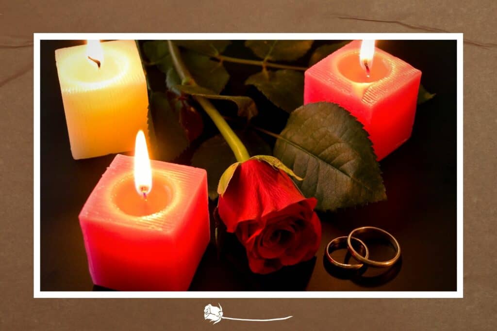 Kerzen mit roter Rose und Eheringe