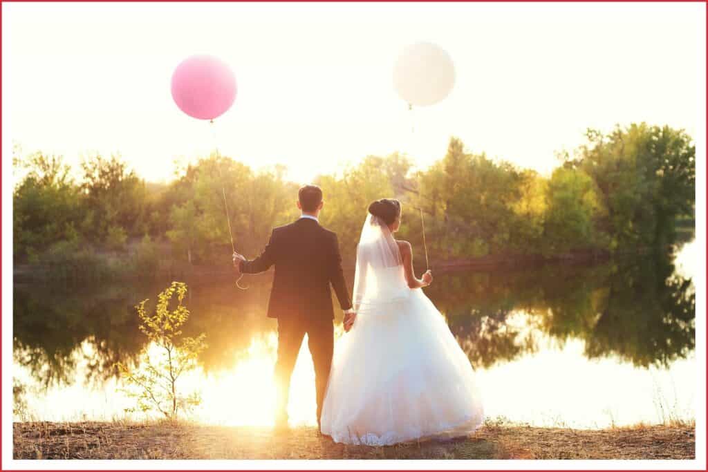 Brautpaar am See mit Luftballon in der Hand. Eine umweltfreundliche Alternative währen Seifenblasen.